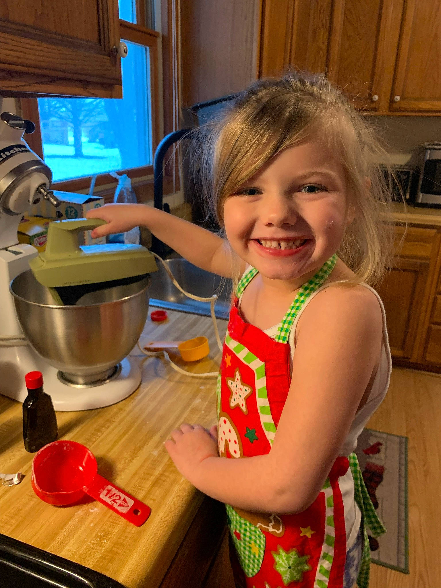 Kadence is registered to the contest to win money with this photo: cabinetry, child, cooking, countertop, drawer, flooring, happy, home_appliance, joy, kitchen, kitchen_appliance, kitchen_stove, kitchen_utensil, major_appliance, person, small_appliance, smile, standing, table, tableware
