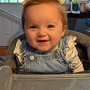 Oakley joined the competition — help win amazing prizes! baby, bows, child, cute, denim_overalls, face, happy, high_chair, home, indoor, infant, person, pigtails, plastic_tray, seated, smiling, table, white_shirt, window, young