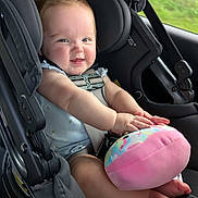 Oakley joined the competition — help win amazing prizes! baby, car_seat, plush_toy, smiling, infant, child, seatbelt, car_interior, happy, cute, toy, safety, window, greenery, legs, hands, face, clothing, transportation, travel