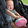 baby, car_seat, plush_toy, smiling, infant, child, seatbelt, car_interior, happy, cute, toy, safety, window, greenery, legs, hands, face, clothing, transportation, travel