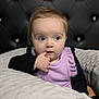 Oakley joined the competition — help win amazing prizes! baby, child, infant, face, blue_eyes, finger_in_mouth, cushion, soft_texture, black_background, tufted_headboard, purple_clothing, long_sleeve, curly_hair, indoor, portrait, cute, thoughtful, resting, closeup, person