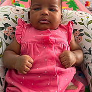 Deborah is registered to the contest to win money with this photo: baby, infant, child, pink_clothing, onesie, polka_dot, floral_cushion, indoor, toy, panda_toy, colorful, cute, portrait, face, hands, expression, seated, young_child, comfortable, closeup