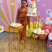 Isabella Rose joined the competition — help win amazing prizes! child, girl, birthday_cake, cake, balloons, party, celebration, floral_outfit, treats, desserts, colorful, decorations, table, stand, happy, smiling, indoors, event, background, gift_bag