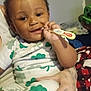 Christopher is registered to the contest to win money with this photo: toddler, child, baby, pajamas, toothbrush, hand, tattoo, indoor, smile, face, person, clothing, cute, holding, pattern, green, white, cozy, happy, infant