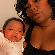 Anaria is registered to the contest to win money with this photo: baby, black_clothing, closeup, curly_hair, cute, expression, eyelashes, face, family, holding, indoor, infant, love, mother_and_child, person, portrait, selfie, skin, white_outfit, woman