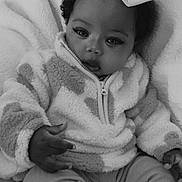 Anaria joined the competition — help win amazing prizes! baby, child, infant, bow, jacket, zipper, curly_hair, blanket, soft_texture, sitting, indoors, portrait, cute, warm_clothing, expression, face, hand, cozy, monochrome, black_and_white