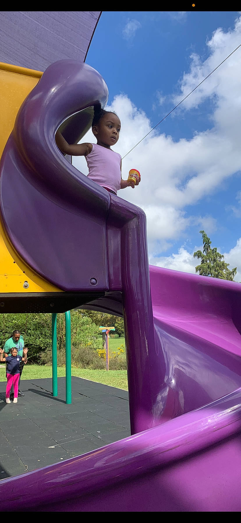 Kayen is registered to the contest to win money with this photo: blurred, chute, city, cloud, fun, green, leisure, magenta, outdoor_play_equipment, outdoor_recreation, person, photograph, pink, plant, playground, playground_slide, purple, recreation, sky, toddler
