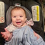 baby, smiling, blanket, car_seat, child, happy, person, clothing, face, hand, infant, indoor, cute, seat, head, fabric, apparel, baby_girl, expression, joy