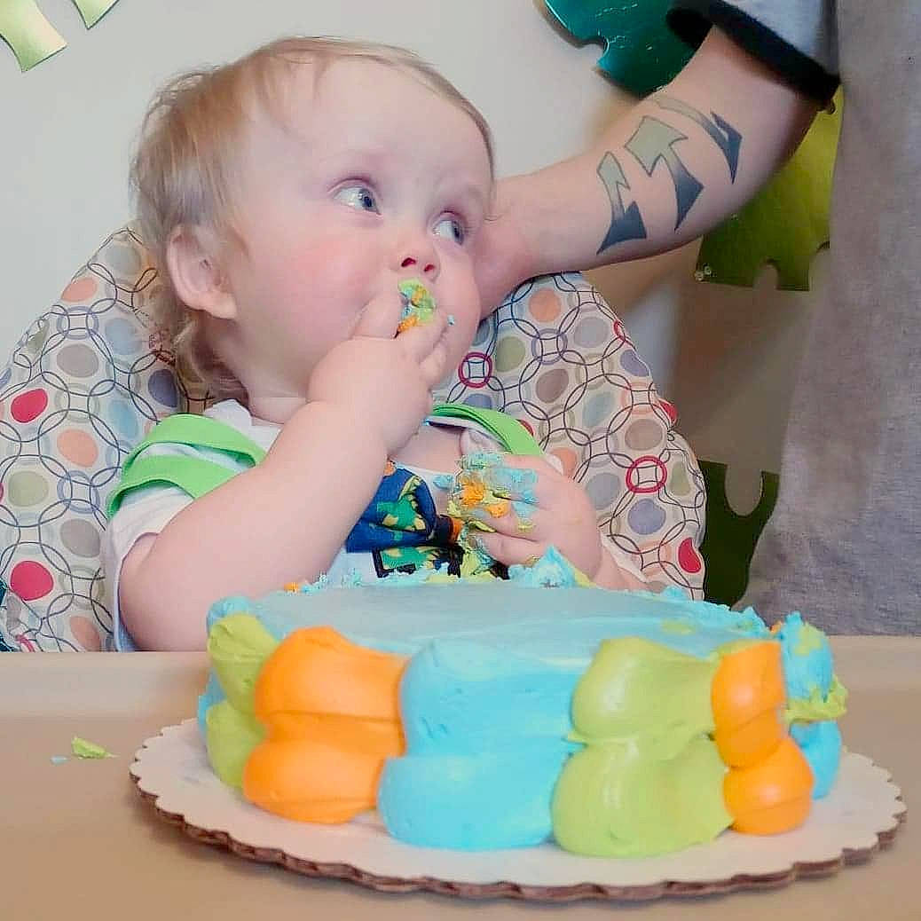 Lyric is registered to the contest to win money with this photo: baby, baby_playing_with_toys, baby_toddler_clothing, baked_goods, birthday_cake, cake_decorating, chair, child, drinkware, food, fun, green, happy, icing, person, sharing, sweetness, table, tableware, toddler