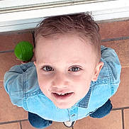 Giullian a rejoint le concours — aidez-le/la à gagner de superbes lots ! child, boy, smiling, face, denim_shirt, green_ball, floor, tile, casual_clothing, short_hair, indoor, playful, looking_up, cute, portrait, happy, person, childhood, young, casual