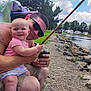 baby, man, fishing_rod, lake, rocks, trees, outdoor, smiling, sunglasses, grass, clouds, water, fishing, child, happy, nature, summer, people, parent, recreation