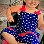 casual, chair, child, cute, daylight, dress, footwear, happy, outdoor, pavement, person, pink_shoes, playful, red_bows, relaxed, sitting, smiling, snack, stars, young