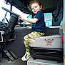 Carl joined the competition — help win amazing prizes! child, steering_wheel, truck_interior, camouflage_pants, sneakers, seat, vehicle, dashboard, pedals, window, smile, redhead, bracelet, door, control_panel, floor, seat_cover, emergency_vehicle, young_child, playful