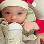 Pennelopea is registered to the contest to win money with this photo: baby, infant, bottle, feeding, milk, red_clothing, hat, towel, hand, face, eyes, cozy, indoors, person, cute, resting, comfort, child, drink, closeup