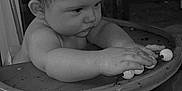Gabriel participe au concours pour gagner de l'argent avec cette photo : baby, black_and_white, child, closeup, concentration, curious, expression, face, foot, furniture, hand, high_chair, indoor, infant, monochrome, portrait, seat, toy, wood, young_child