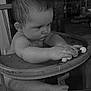 baby, black_and_white, child, closeup, concentration, curious, expression, face, foot, furniture, hand, high_chair, indoor, infant, monochrome, portrait, seat, toy, wood, young_child