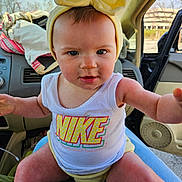 Marlene is registered to the contest to win money with this photo: baby, child, yellow_bow, tank_top, nike_logo, car_interior, person, face, legs, arms, window, seat, clothing, headwear, expression, sunlight, jeans, hand, dashboard, seatbelt