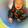 Léon participe au concours pour gagner de l'argent avec cette photo : child, clothing, colorful, crawling, cute, expression, face, fun, hands, happy, jacket, levi's, outdoor, person, play, playground, smiling, toddler, tunnel, young