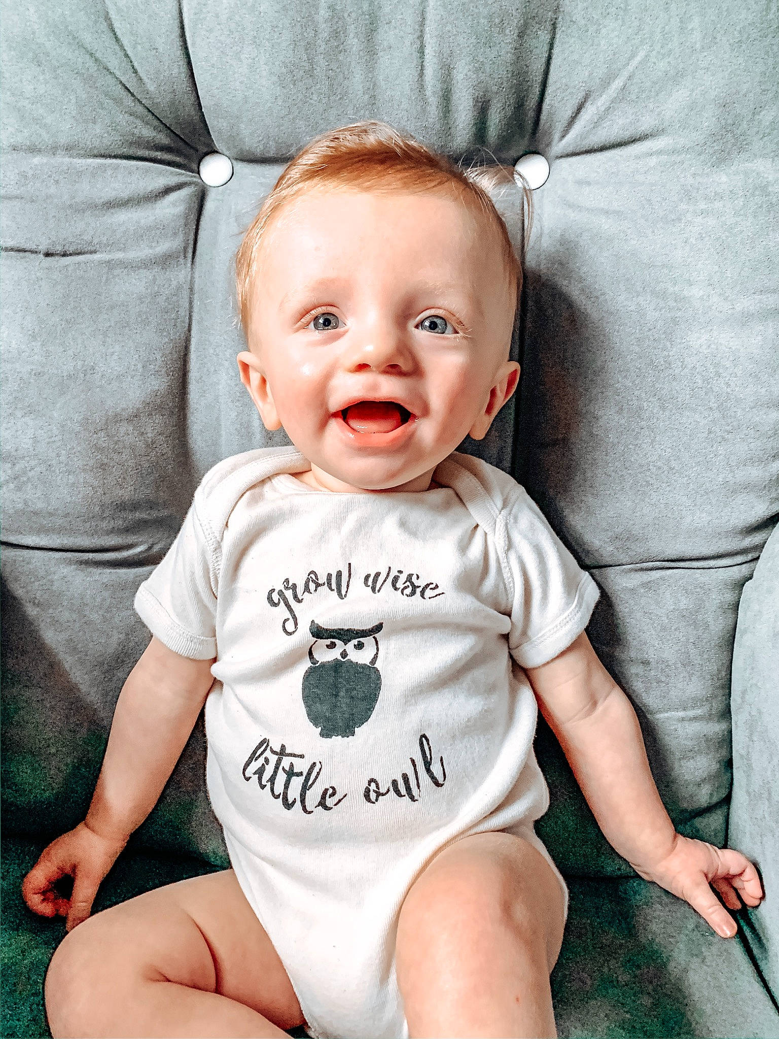 Brett is registered to the contest to win money with this photo: baby, baby_laughing, baby_products, baby_toddler_clothing, child, facial_expression, head, person, product, sitting, sleeve, smile, t_shirt, toddler