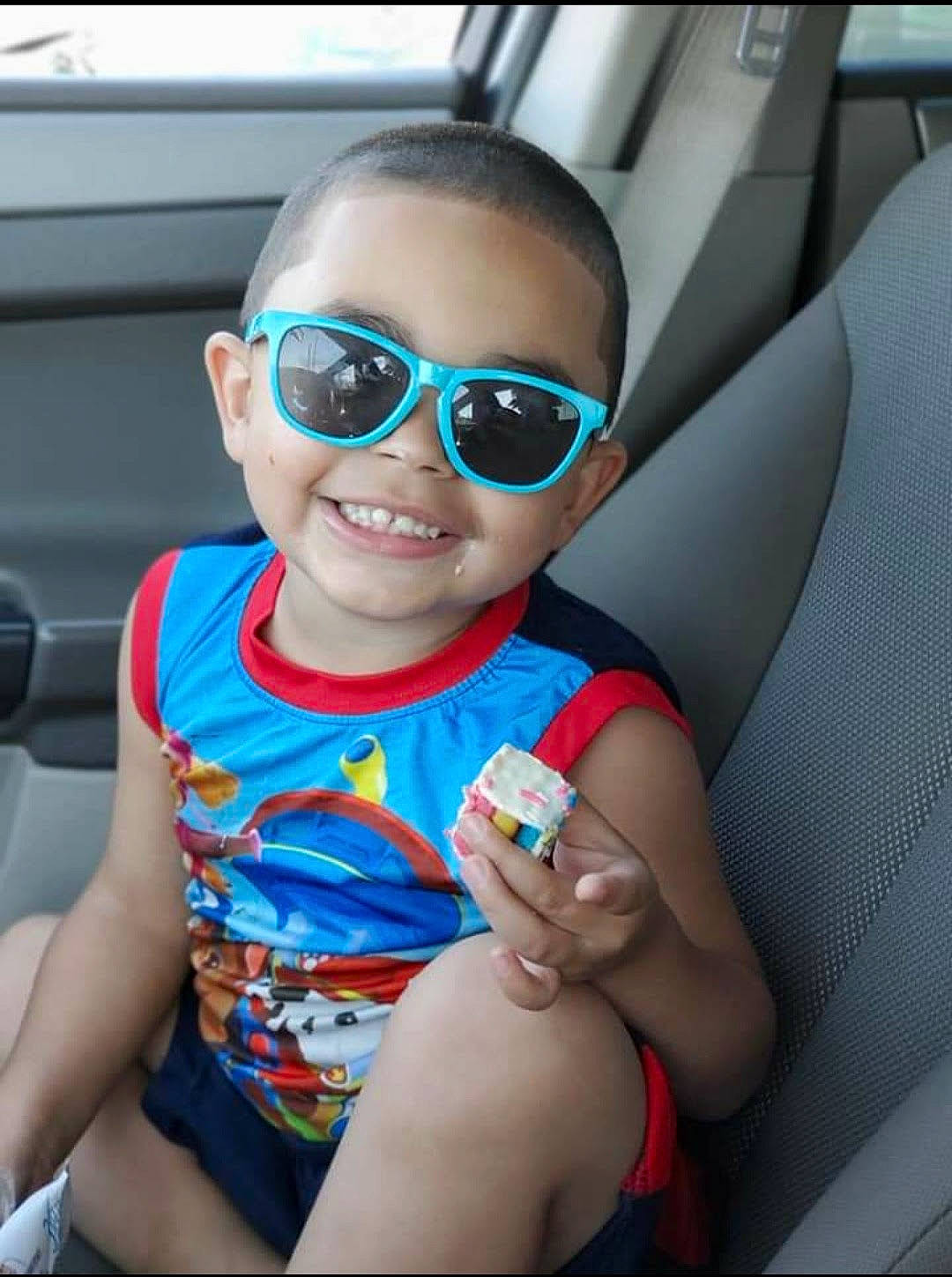 Jaymeson is registered to the contest to win money with this photo: automotive_design, car, car_seat, cool, dress, eyewear, face, finger, gesture, goggles, hairstyle, joy, mouth, person, skin, smile, sunglasses, thigh, thumb, toddler