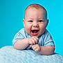baby, blanket, blue_background, child, closeup, clothing, cute, expression, face, hands, happy, head, human, infant, light_skin, portrait, smiling, soft_texture, studio, young