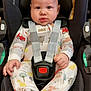 baby, infant, car_seat, maxi_cosi, onesie, straps, child, cute, face, hands, feet, sitting, safety, indoor, expression, clothing, pattern, seatbelt, transportation, adorable