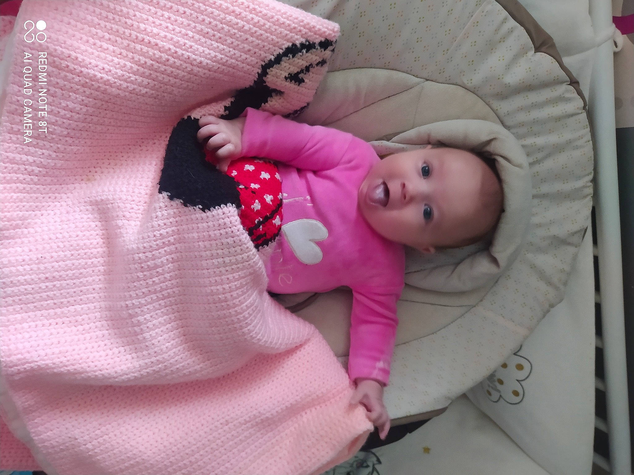 Angèla a rejoint le concours — aidez-le/la à gagner de superbes lots ! baby, baby_products, baby_sleeping, baby_toddler_clothing, cheek, child, comfort, eye, finger, head, linens, magenta, pattern, person, pink, purple, sitting, sleeve, textile, toddler