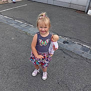 Angèla participe au concours pour gagner de l'argent avec cette photo : asphalt, blonde_hair, butterfly, casual_clothing, child, curb, doll, dress, girl, hair_bow, happy, outdoor, pavement, person, pink_shoes, play, sidewalk, smiling, toy, urban