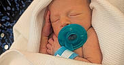 Magnolia is registered to the contest to win money with this photo: baby, blanket, closeup, comfort, cute, face, hand, hospital_wristband, indoor, infant, newborn, pacifier, peaceful, person, portrait, resting, skin, sleeping, soft_texture, wrapped
