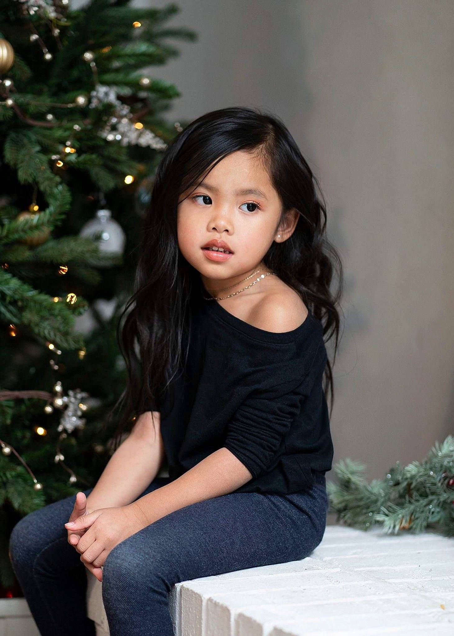 Saphira is registered to the contest to win money with this photo: beauty, black_hair, child, child_model, christmas, holiday, long_hair, person, photo_shoot, photography, sitting, smile, standing, tree