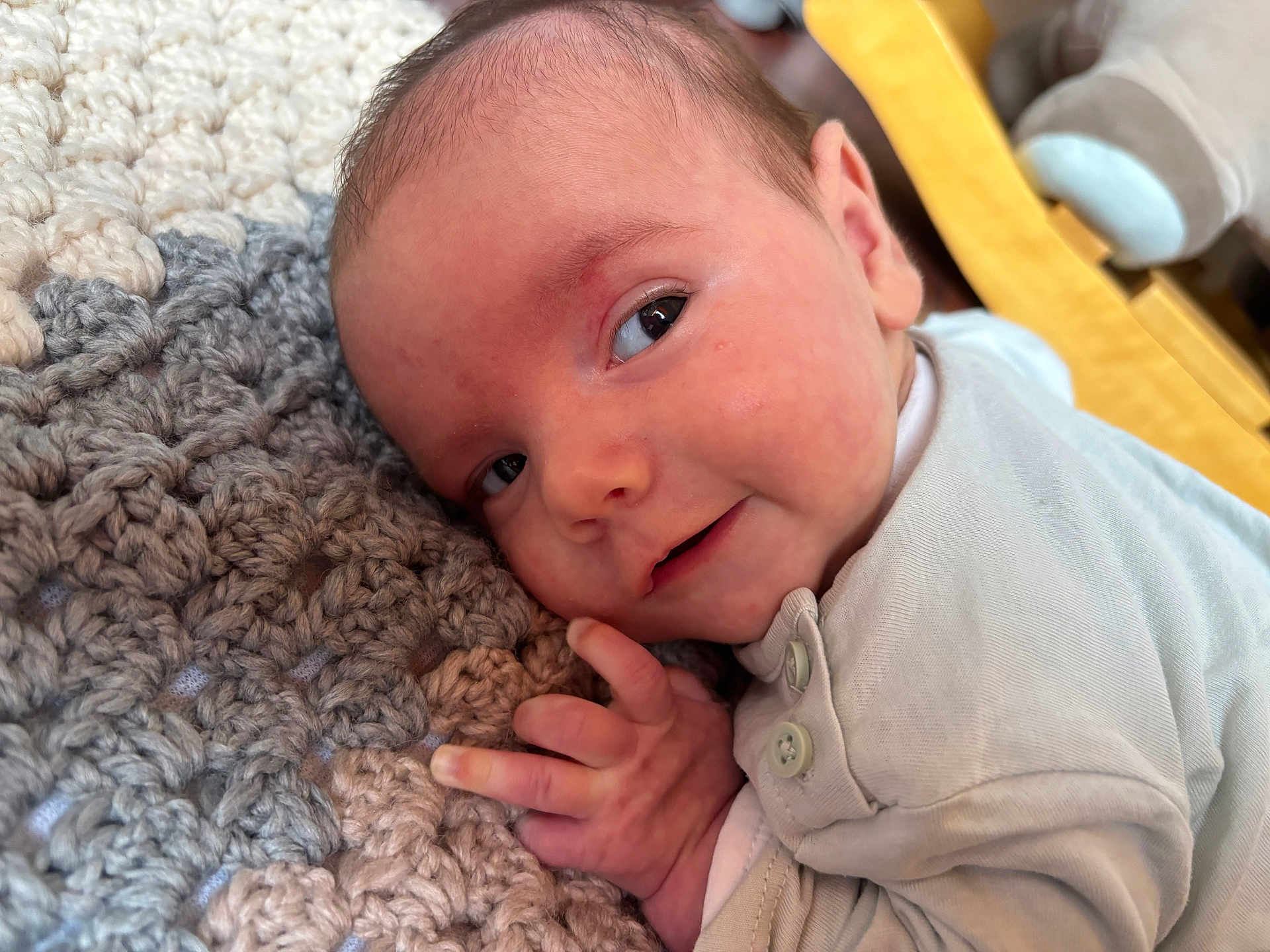 Manoa a rejoint le concours — aidez-le/la à gagner de superbes lots ! baby, infant, face, smile, hand, knitted_blanket, texture, closeup, newborn, clothing, laying_down, cute, young_child, skin, head, eyes, indoor, soft_light, portrait, expression