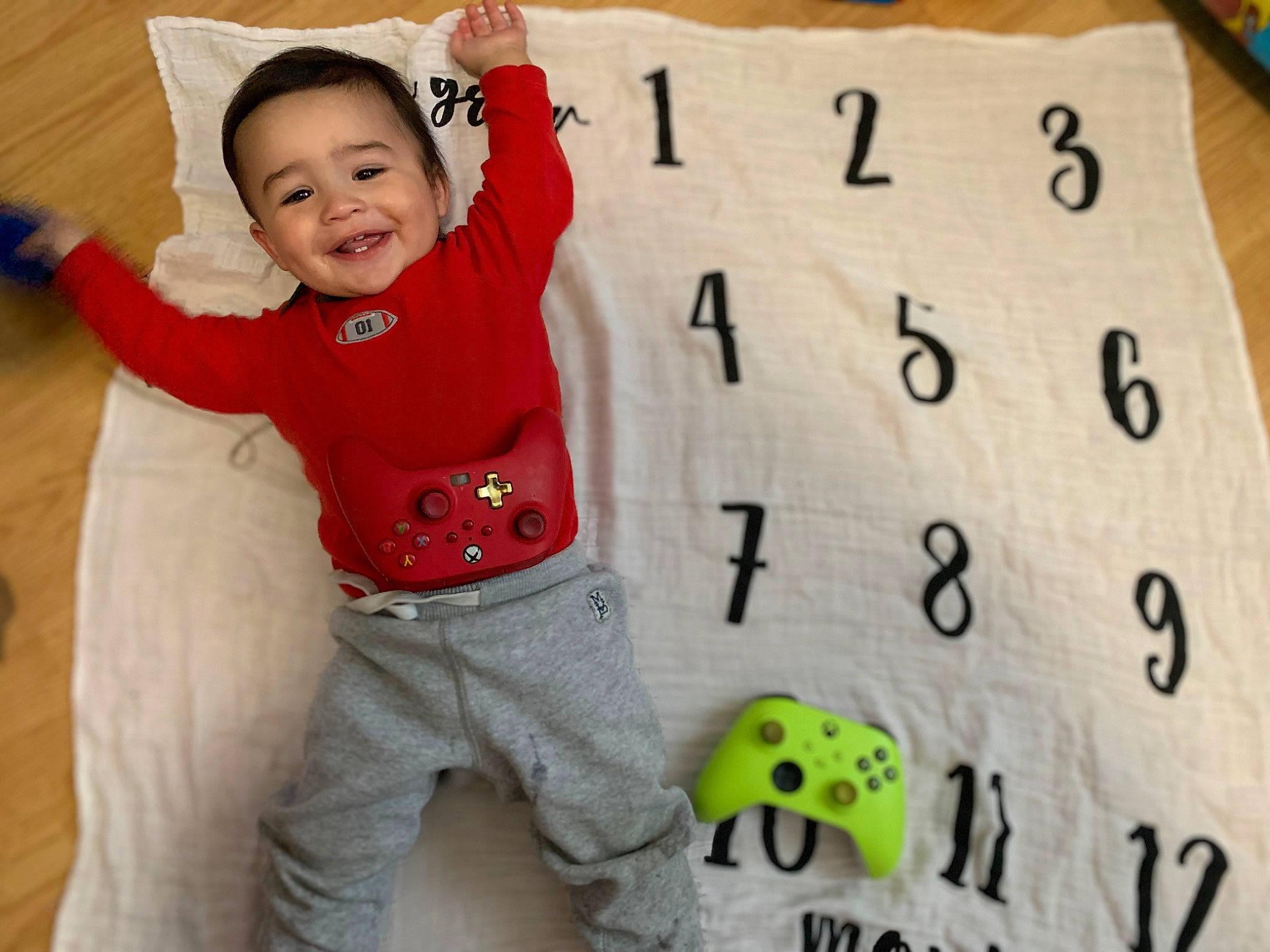 Phillip is registered to the contest to win money with this photo: baby, baby_laughing, baby_toddler_clothing, child, facial_expression, flooring, font, fun, happy, indoor_games_and_sports, joy, number, pattern, person, play, sleeve, smile, t_shirt, toddler, white