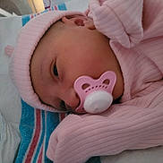 Amelia is registered to the contest to win money with this photo: newborn, baby, pacifier, pink_clothing, hat, blanket, sleeping, infant, closeup, face, soft_lighting, indoors, cute, resting, child, portrait, cozy, striped_blanket, early_morning, peaceful