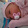 newborn, baby, pacifier, pink_clothing, hat, blanket, sleeping, infant, closeup, face, soft_lighting, indoors, cute, resting, child, portrait, cozy, striped_blanket, early_morning, peaceful