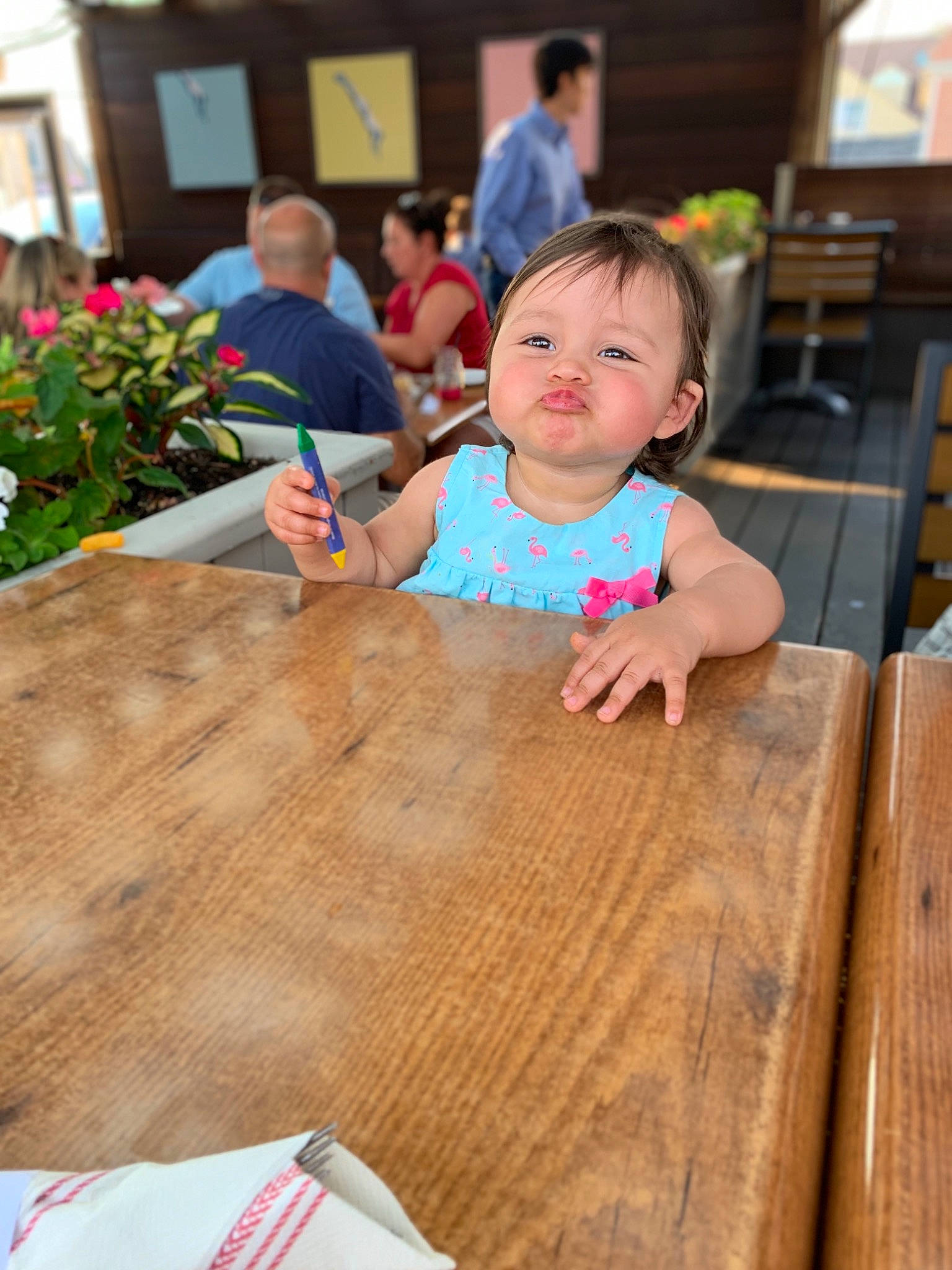 Elliana is registered to the contest to win money with this photo: baby, child, face, finger, floor, flooring, hand, hardwood, head, leisure, people, person, play, recreation, restaurant, smile, summer, table, toddler, vacation