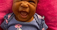 Azaliah is registered to the contest to win money with this photo: baby, child, infant, smiling, purple_clothing, floral_pattern, cushion, pink, happy, face, portrait, cute, lying_down, indoors, skin, head, expression, person, baby_girl, closeup