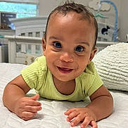 Aidan is registered to the contest to win money with this photo: baby, bed, child, cloud_decor, crib, cute, face, green_shirt, hand, happy, home, indoor, infant, lying_down, nursery, person, pillow, quilted_bedspread, smiling, young_child
