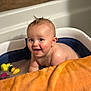 baby, bathtub, bath, water, rubber_duck, toy, orange_towel, child, smiling, wet_hair, skin, indoor, happy, cute, infant, playful, splashing, fun, tub, portrait