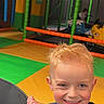 Eden participe au concours pour gagner de l'argent avec cette photo : child, smiling, indoor_playground, blonde_hair, blue_sweater, round_table, colorful_floor, play_area, soft_play, ride_on_toy, happy, young_child, playtime, fun, kid, play_equipment, bright_colors, leisure, casual_clothing, portrait