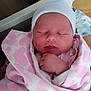 Miley joined the competition — help win amazing prizes! newborn, baby, sleeping, blanket, pink, heart_pattern, hat, infant, wrapped, hand, person, closeup, face, soft, cute, resting, indoors, cozy, portrait, peaceful