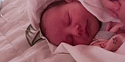 Miley is registered to the contest to win money with this photo: newborn, baby, sleeping, blanket, soft, bedspread, quilt, star_pattern, clothing, infant, peaceful, resting, wrapped, face, closed_eyes, hand, skin, indoors, cozy, cute