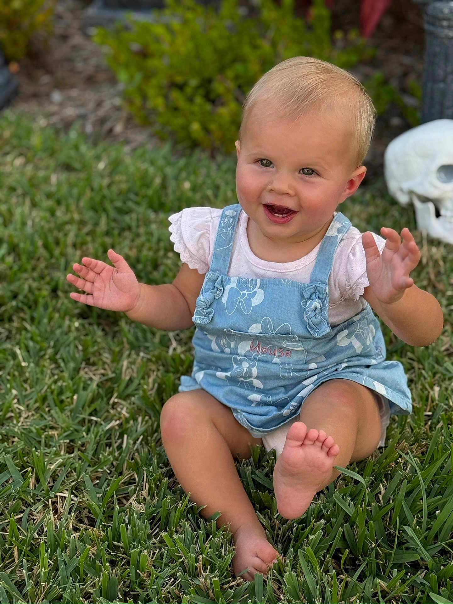 Lauren is registered to the contest to win money with this photo: baby, child, grass, outdoor, smiling, blue_dress, barefoot, face, greenery, cute, happy, person, skull_decoration, nature, summer, playful, sitting, toddler, hands, foot