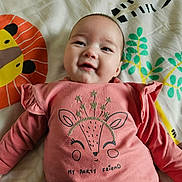 Hélya a rejoint le concours — aidez-le/la à gagner de superbes lots ! baby, infant, smiling, onesie, blanket, pillow, bedding, pattern, animal_print, cute, happy, face, eyes, cheeks, mouth, glitter, sparkles, shirt, lying_down, indoors