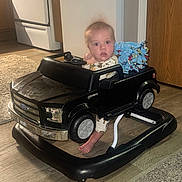 Luke joined the competition — help win amazing prizes! baby, child, toy_car, walker, indoor, floor, carpet, blanket, curious, hair, foot, kitchen, appliance, door, wood, flooring, clothing, seat, person, furniture