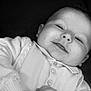 baby, black_and_white, buttoned, child, close_up, clothing, cozy, cute, expression, face, hands, indoor, infant, newborn, peaceful, portrait, smile, soft_light, sweater, young