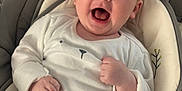 Tommy is registered to the contest to win money with this photo: baby, infant, smiling, happy, cute, pajamas, bear_pattern, baby_seat, cushion, comfort, indoor, child, young, face, hands, clothing, seatbelt, expression, portrait, relax
