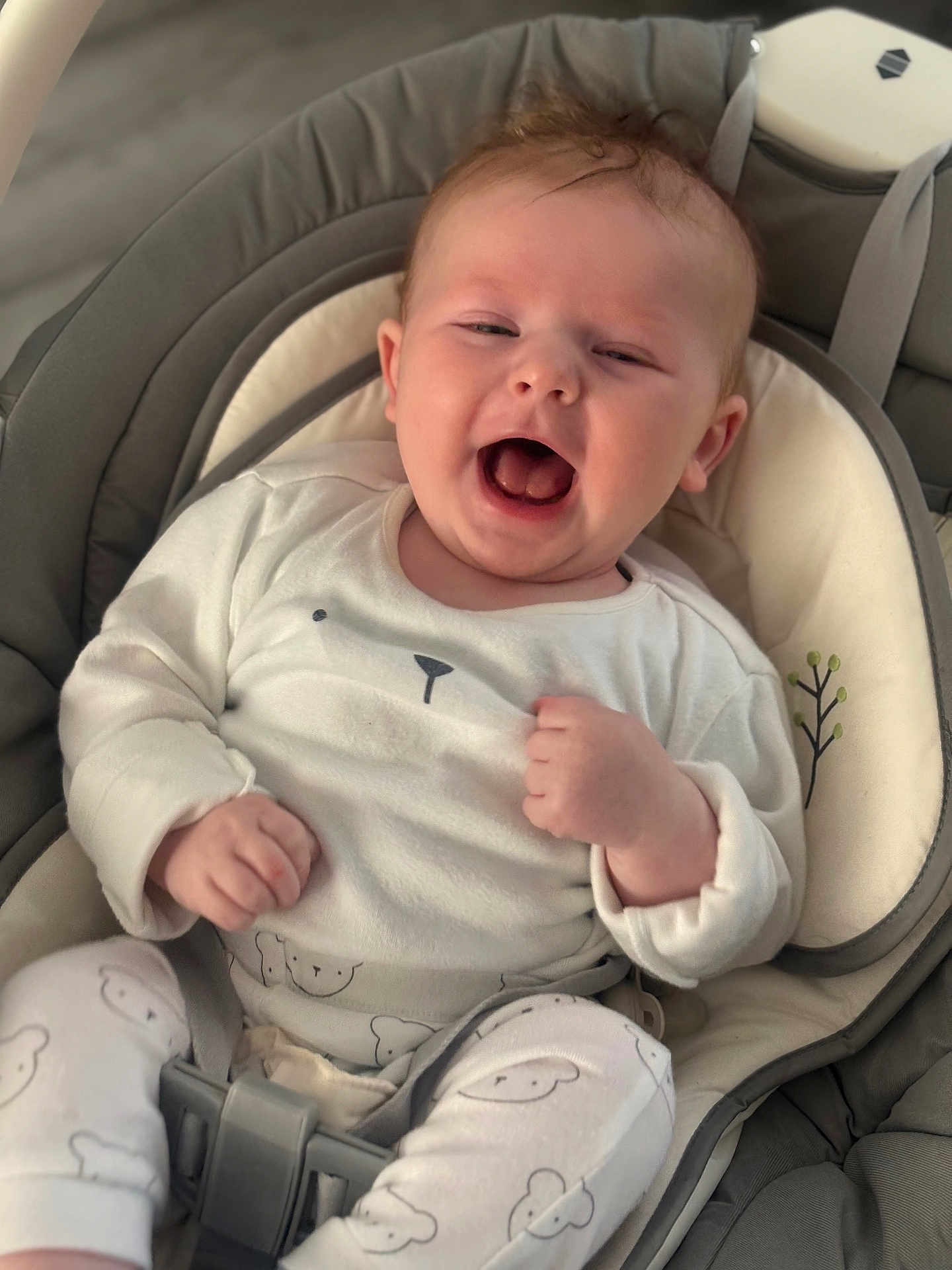 Tommy is registered to the contest to win money with this photo: baby, infant, smiling, happy, cute, pajamas, bear_pattern, baby_seat, cushion, comfort, indoor, child, young, face, hands, clothing, seatbelt, expression, portrait, relax