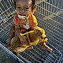 toddler, child, puppy, dog, shopping_cart, pacifier, clip, smiling, barefoot, outdoor, metal, grid, cute, pet, happy, young_child, playful, animal, infant, holding