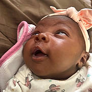 Kybria joined the competition — help win amazing prizes! baby, infant, headband, bow, clothing, blanket, face, expression, looking_up, closeup, soft, cute, patterned_outfit, child, newborn, indoors, person, skin, head, cozy