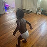 toddler, child, diaper, wooden_floor, indoor, door, window, toy_car, pink_car, walking, person, home, living_room, floorboards, natural_light, curtains, playtime, baby, young_child, casual